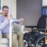 Man using the Adantage Rail to transfer safely from a living room chair to a wheelchair