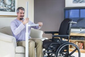 Man using the Adantage Rail to transfer safely from a living room chair to a wheelchair