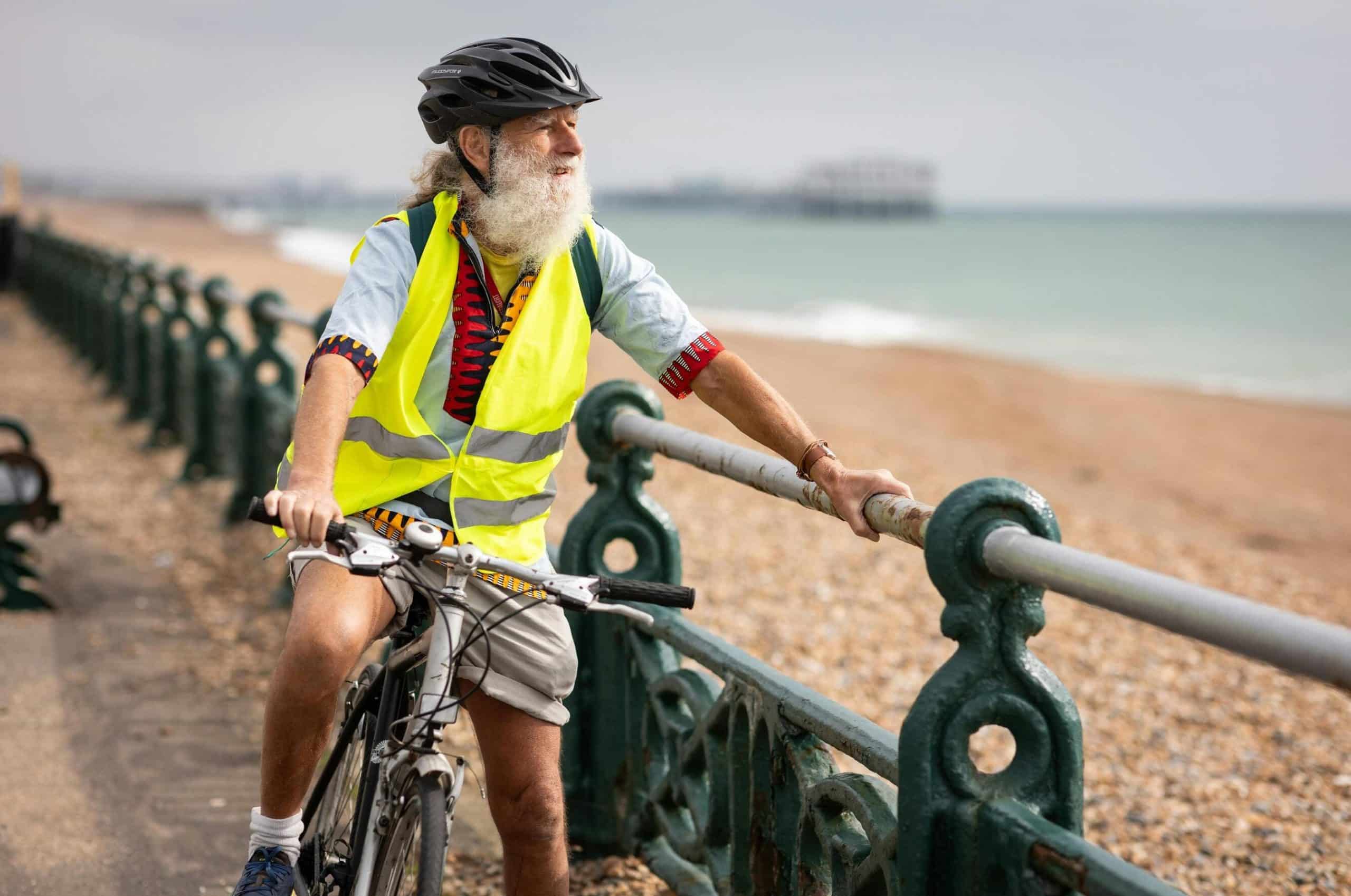 Older gentleman holding onto a railing as he takes a break from biking