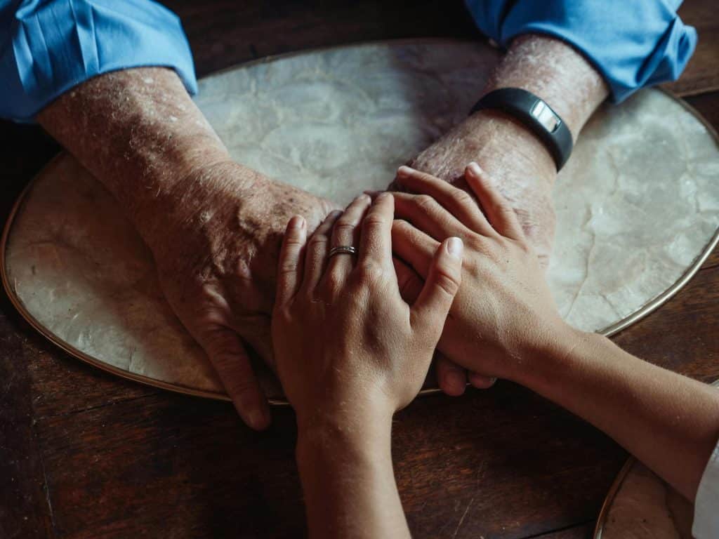 two people holding hands, one is a man one is a woman