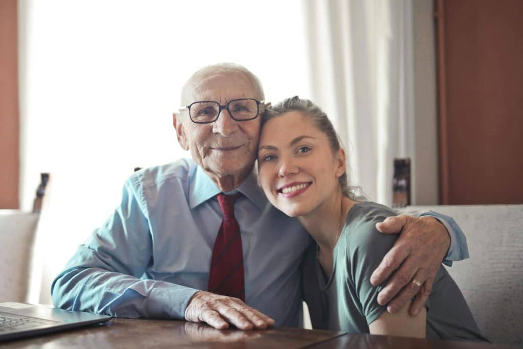 an elderly man embracing his younger family member